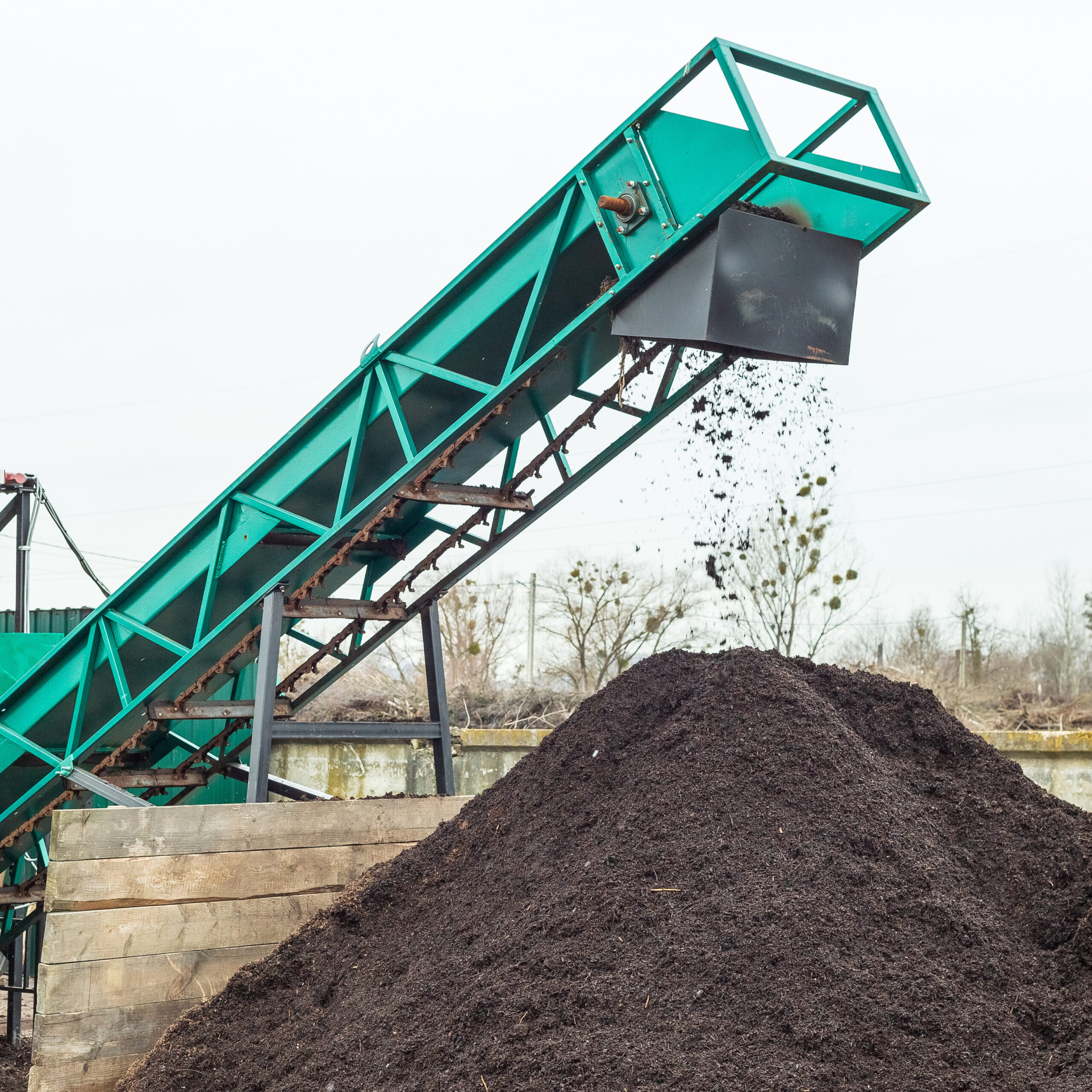 Producing soil at industrial compost plant. Sifting soil with a machinery to make clean earth ready to be used