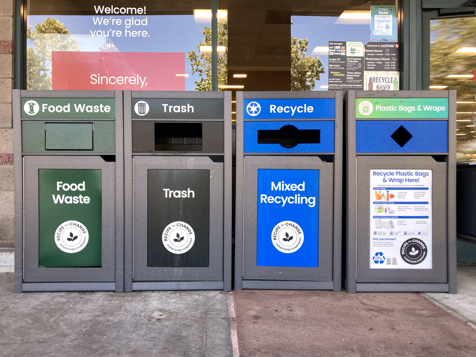 Four labeled bins for different types of waste: Food Waste, Trash, Mixed Recycling, and Recycle Plastic Bags and Wraps at the entrance to store - San Jose, California, USA - June 9, 2024